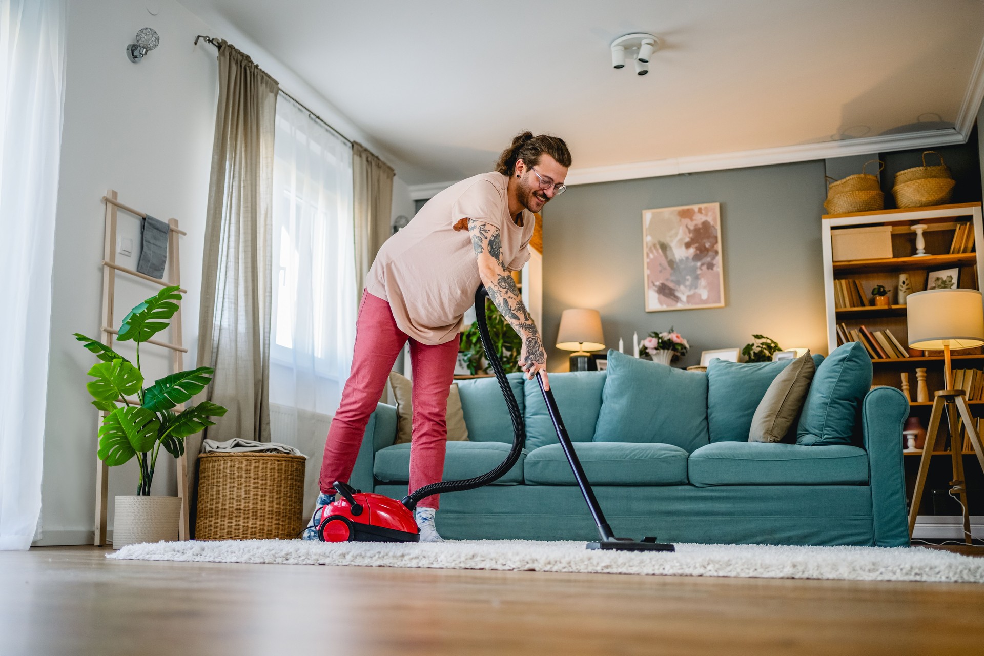 Man cleaning house with vacuum cleaner